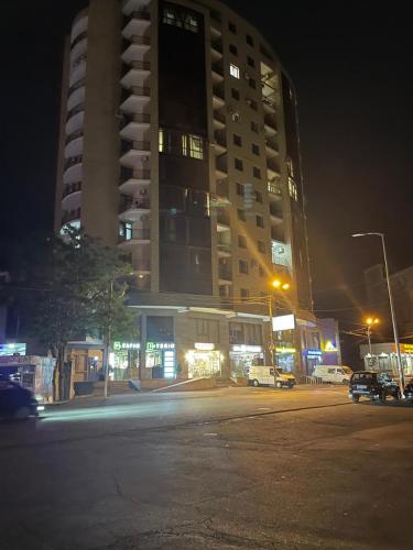 a large tall building at night with a parking lot at Apartment in centre of Yerevan in Yerevan