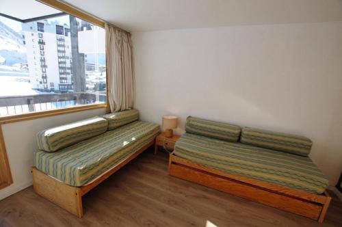deux lits dans une chambre avec une fenêtre dans l'établissement Résidence Home Club 2 - Plusieurs studios disponibles pour vos séjours en famille ou entre amis MAE-2744, à Tignes