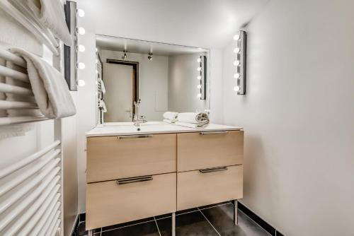 une salle de bain avec un lavabo et un miroir dans l'établissement Résidence Hameaux De Toviere - Appartement élégant sur 3 niveaux - vue panoramique MAE-3034, à Tignes