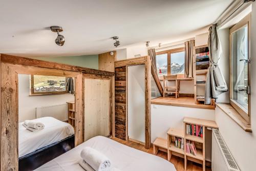 une chambre avec deux lits et une fenêtre dans l'établissement Résidence Hameaux De Toviere - Appartement élégant sur 3 niveaux - vue panoramique MAE-3034, à Tignes