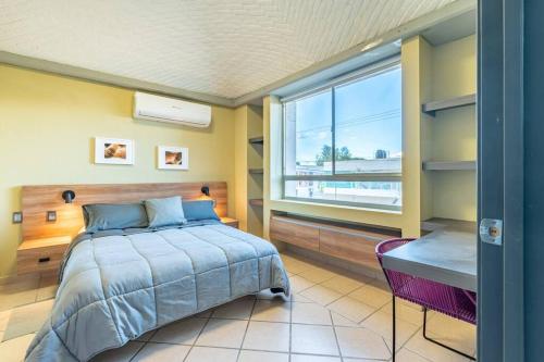a bedroom with a bed and a large window at Hermoso Depa en Centro Historico con Mini split in Durango