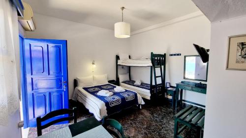 a bedroom with a blue door and a bed and a desk at Xylokeratidi Sea View Family Studio in Rakhídhion