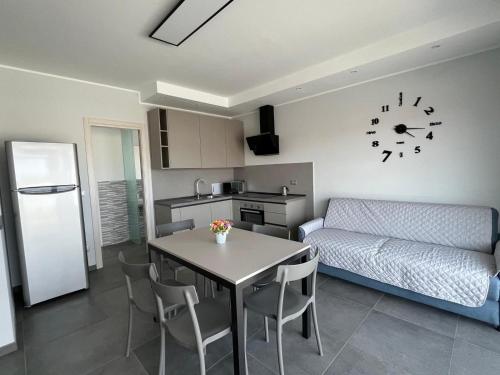 a kitchen and a living room with a table and a couch at Mini Condominio Privato in Loano