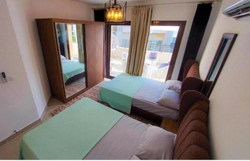 une chambre avec un lit et un grand miroir dans l'établissement Marina marassi, à Sīdī ‘Abd ar Raḩmān