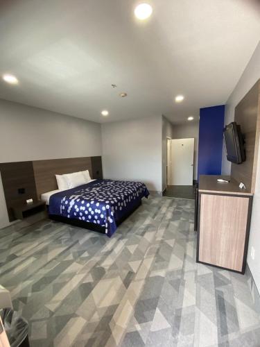 a hotel room with a bed and a flat screen tv at Airway Inn - IAH Airport in Houston