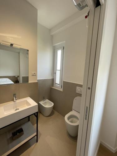 a bathroom with a sink and a toilet and a mirror at Sirolo appartamenti in Sirolo