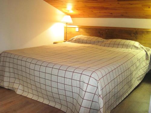 une chambre avec un lit avec une couverture à carreaux dans l'établissement Le Chalet De Montchavin - Beau studio duplex proche du centre MAE-8874, à La Plagne Tarentaise