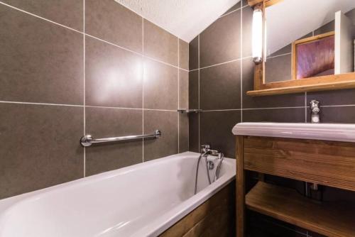 La salle de bains est pourvue d'une baignoire blanche et d'un lavabo. dans l'établissement Le Chalet De Montchavin - Beau studio duplex proche du centre MAE-8874, à La Plagne Tarentaise