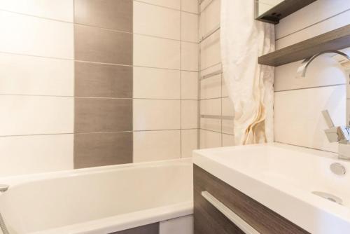 une salle de bain avec une baignoire blanche et un lavabo dans l'établissement Résidence Le Bastion I - Studio cabine entièrement rénové MAE-8894, à La Plagne Tarentaise