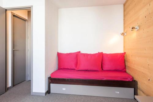 - un canapé rouge avec des oreillers rouges dans l'établissement Résidence Les Choucas - Studio rénové, pied des pistes MAE-9004, à Aime La Plagne
