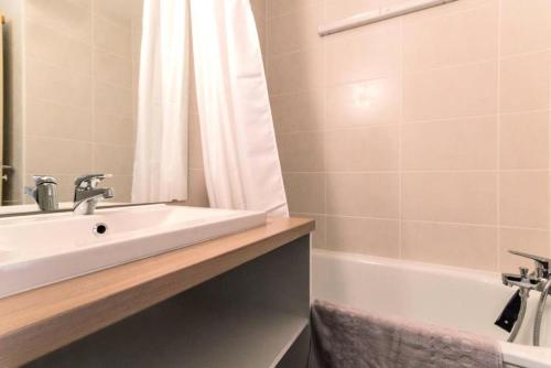 une salle de bain avec un lavabo et une baignoire dans l'établissement Résidence La Traverse - Studio entièrement rénové MAE-8924, à La Plagne Tarentaise