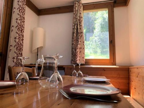 - une table à manger avec des verres à vin et une fenêtre dans l'établissement Le Chalet De Montchavin - Très beau studio spacieux MAE-9014, à La Plagne Tarentaise
