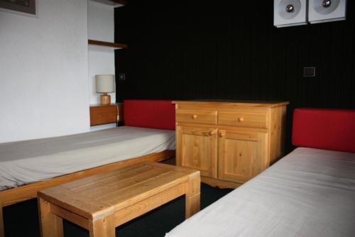 - une chambre avec 2 lits, une table et un banc en bois dans l'établissement Résidence Les Pentes - Studio divisible en plein centre des Coches MAE-9084, à La Plagne Tarentaise