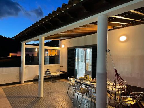 a patio with a table and chairs on a deck at Casa da Adega in Ribeira Chã