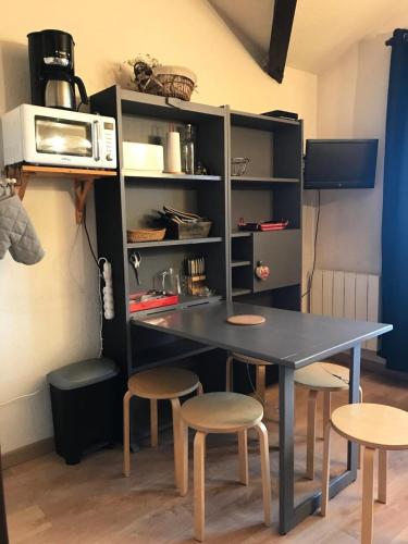 - une table et des tabourets dans la cuisine équipée d'un four micro-ondes dans l'établissement Résidence Le Christiana - Studio sur les pistes MAE-9194, à Aime La Plagne