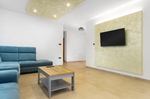 a living room with a couch and a tv on a wall at Pensiunea Patakparti 4 in Praid