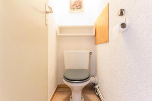 Elle comprend une petite salle de bains pourvue de toilettes et d'un siège vert. dans l'établissement Résidence Les Avrieres Bas - Studio proche du centre de Montchavin MAE-9234, à La Plagne Tarentaise