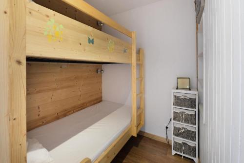 Ce lit superposé se trouve dans une petite chambre dotée de murs en bois. dans l'établissement Résidence Diamant - Studio pour 4 Personnes 204, à La Plagne Tarentaise