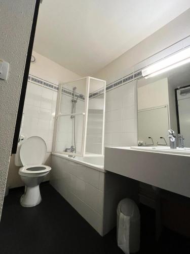une salle de bain blanche avec des toilettes et un lavabo dans l'établissement Résidence Zodiac - Studio pour 4 Personnes 454, à Aime La Plagne