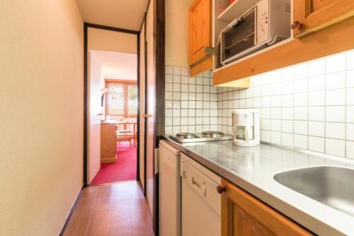 une cuisine avec un évier et un plan de travail dans l'établissement Résidence Le France - Studio 4 personnes Plagne Centre MAE-4744, à La Plagne Tarentaise