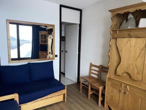 - une chambre avec un canapé bleu et un miroir dans l'établissement Résidence Etoile - Studio pour 2 Personnes 524, à La Plagne Tarentaise