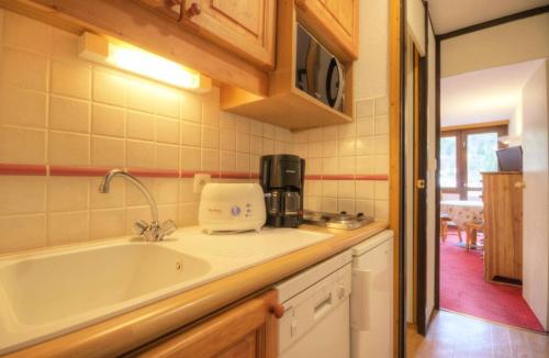 - une cuisine avec évier et cafetière sur le comptoir dans l'établissement Résidence Le France - studio 4 personnes Plagne Centre MAE-4674, à Aime La Plagne