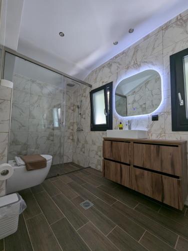 a bathroom with a tub and a toilet and a sink at Villa Selini in Skala Potamias
