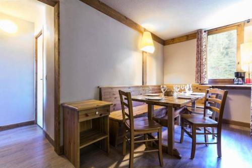 une salle à manger avec une table et des chaises en bois dans l'établissement Le Chalet De Montchavin - Bel appartement proche du centre MAE-4354, à La Plagne Tarentaise