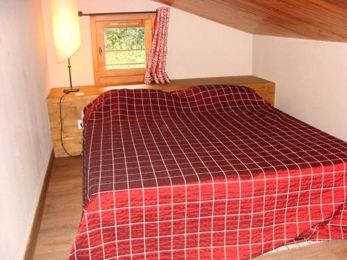a bedroom with a bed with a red plaid blanket at Le Chalet De Montchavin - Bel appartement sous les toits vue Mont Blanc MAE-4414 in La Plagne Tarentaise
