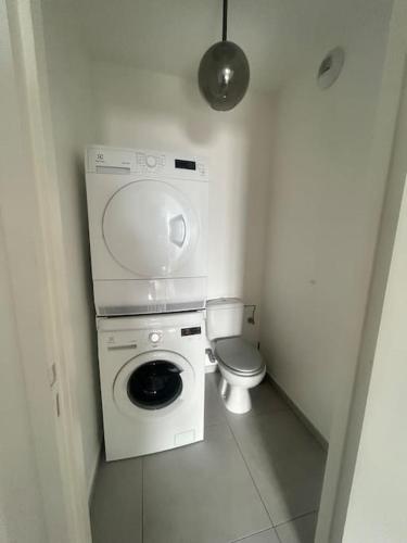 une petite salle de bains avec un lave-linge et des toilettes. dans l'établissement Appartement Rocade, à Ajaccio