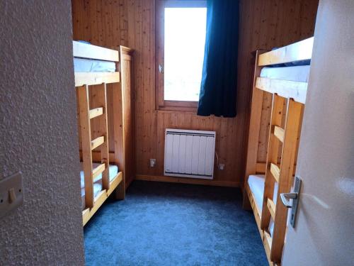 une chambre avec deux lits superposés et une fenêtre dans l'établissement Résidence Plein Soleil - Appartement 2 pièces 6 personnes Plagne Villages MAE-4484, à La Plagne Tarentaise