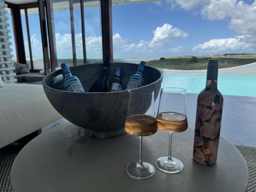 a basket of wine bottles and glasses on a table at Pousada Mestizo in São Miguel do Gostoso