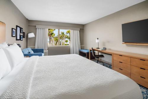 a hotel room with a large bed and a desk at Four Points by Sheraton Destin - Fort Walton Beach in Fort Walton Beach