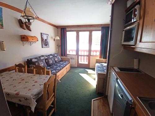 Il dispose d'une cuisine et d'un salon avec un canapé et une table. dans l'établissement Résidence Mont Soleil B - Appartement 5 personnes - Plagne Soleil MAE-4614, à La Plagne Tarentaise
