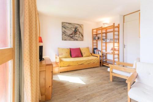 un salon avec un canapé jaune et une table dans l'établissement Résidence Le Bastion I - Très joli deux pièces MAE-4654, à La Plagne Tarentaise