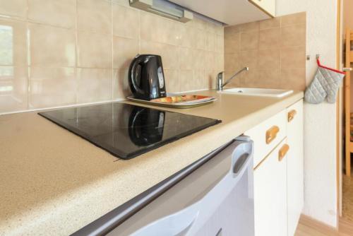 une petite cuisine avec un évier et un micro-ondes dans l'établissement Résidence Le Chanteloup - Appartement pied des pîstes MAE-4694, à Aime La Plagne