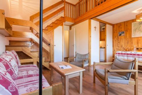 - un salon avec des escaliers, une table et des chaises dans l'établissement Résidence La Porte De Montchavin - En plein coeur de Montchavin MAE-4724, à La Plagne Tarentaise