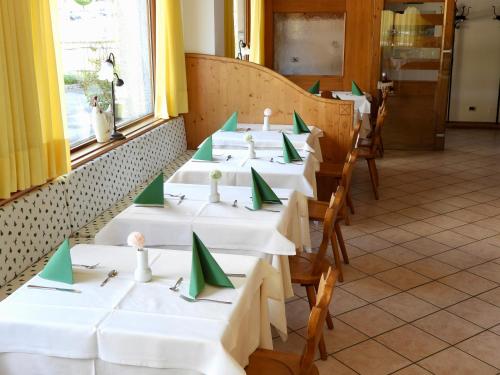 a row of tables in a restaurant with green napkins at Hotel Garnì Maffei in Pinzolo