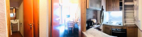 une cuisine avec une porte orange et une cuisine avec un évier dans l'établissement Résidence Les Choucas - Appartement duplex sur les pistes MAE-4794, à Aime La Plagne