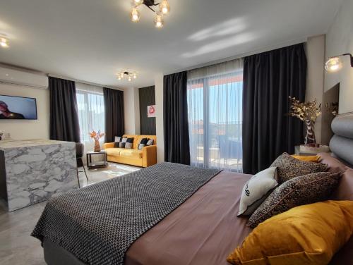 a bedroom with a large bed and a living room at студио Водолей in Obzor