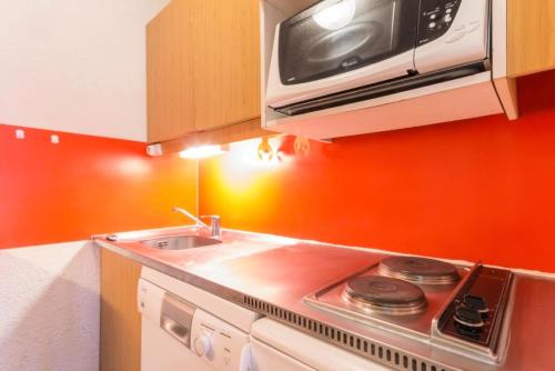 une cuisine avec une cuisinière et un micro-ondes dans l'établissement Résidence La Rochette - Appartement proche du centre de Montchavin MAE-4834, à Aime La Plagne