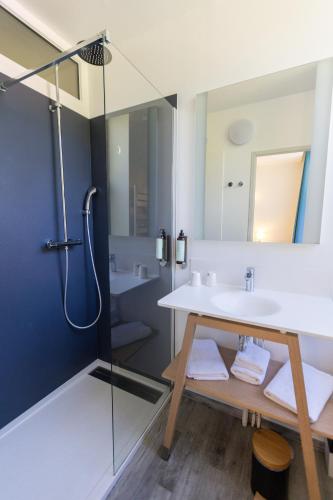 une salle de bain avec un lavabo et une douche dans l'établissement Hotel Les Bellugues, à Saint-Jean-du-Gard