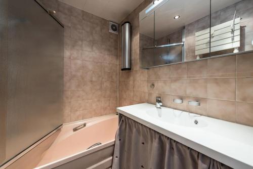 une salle de bain avec un lavabo et une baignoire dans l'établissement Résidence Hauts Lieux - Grand studio cabine au centre de Tignes Le Lac MAE-7414, à Tignes
