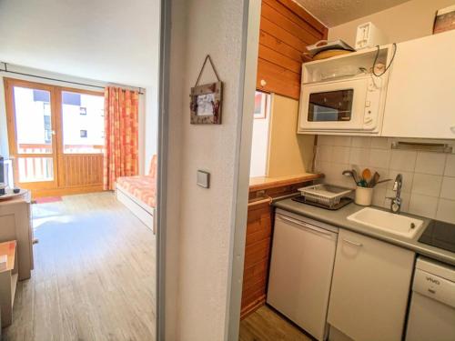 une petite cuisine avec un évier et un micro-ondes dans l'établissement Résidence Hameau Du Borsat 3 - Studio cabine au pied des remontées mécaniques MAE-7534, à Tignes