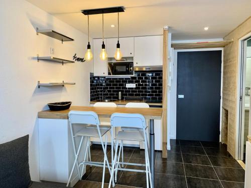 - une cuisine avec un comptoir en bois et des tabourets dans l'établissement Résidence Hameau Du Borsat 1& 2 - Studio 22 m² entièrement rénové MAE-7544, à Tignes