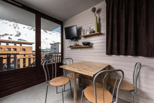 une salle à manger avec une table et des chaises sur un balcon dans l'établissement Nouvelles Residences - Studio avec balcon MAE-7614, à Tignes