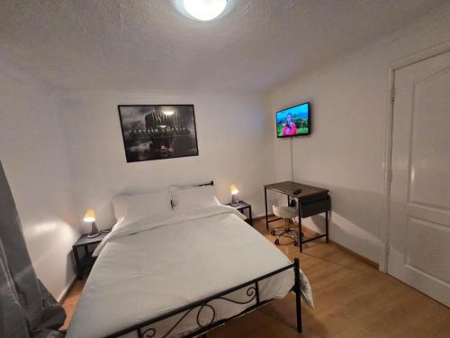 a bedroom with a bed and a table and a television at MeadThames View in Thamesmead