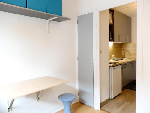 - une petite cuisine avec une table en bois et un tabouret bleu dans l'établissement Résidence Grande Balme Ii - Studio 16-20m² à l'entrée de Tignes MAE-7704, à Tignes