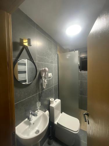 a bathroom with a toilet and a sink and a mirror at Villa Villekulla VV in Kolašin