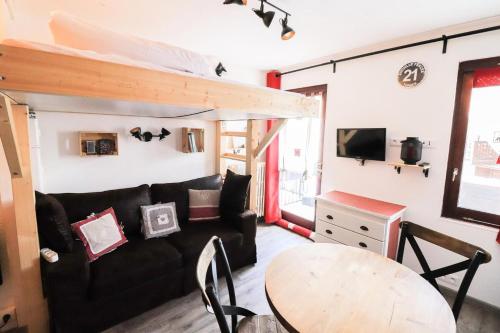 un salon avec un canapé noir et une table dans l'établissement Résidence Glaciers - Studette pour 2 personnes au Lavachet MAE-7724, à Tignes